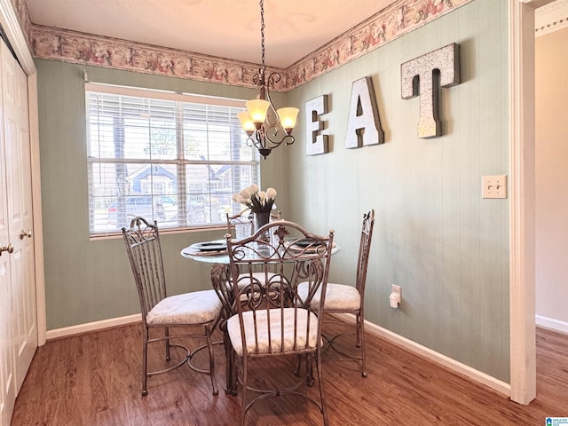 dining area featuring wood-type flooring and a notable chandelier