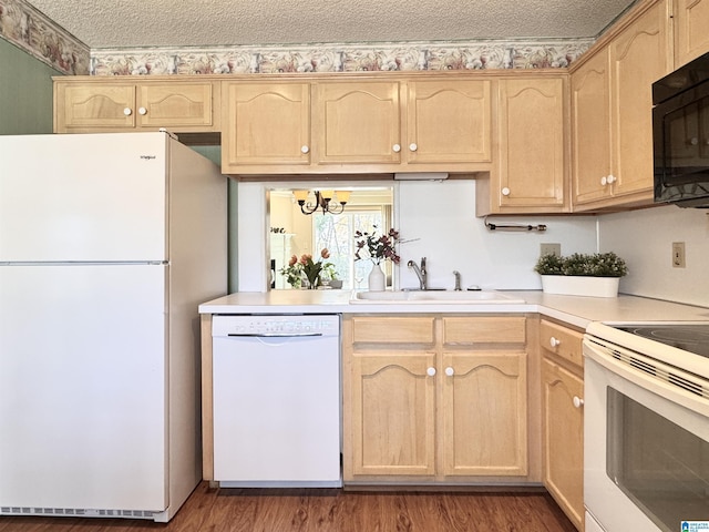 kitchen with a textured ceiling, sink, white appliances, and light brown cabinets