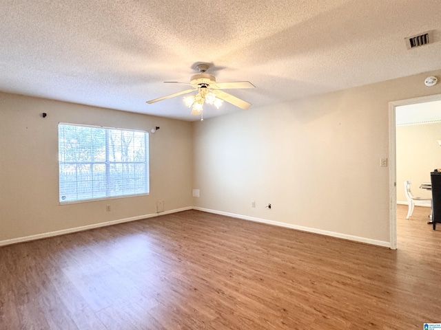 empty room with ceiling fan, dark hardwood / wood-style flooring, and a textured ceiling