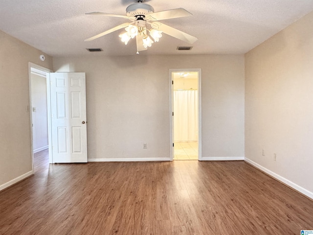 empty room featuring ceiling fan, dark hardwood / wood-style flooring, and a textured ceiling