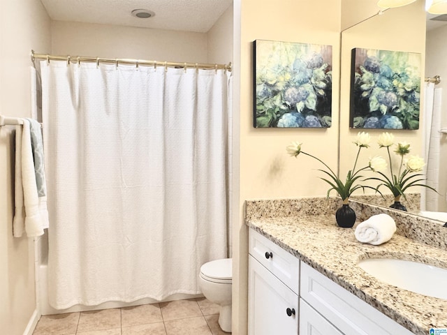 bathroom with tile patterned floors, vanity, a textured ceiling, and toilet