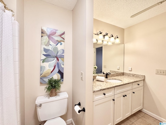 bathroom featuring tile patterned floors, ceiling fan, vanity, and a textured ceiling