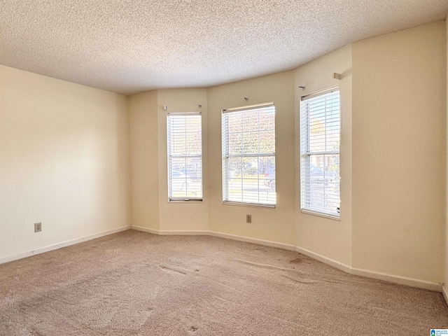 carpeted empty room featuring a textured ceiling