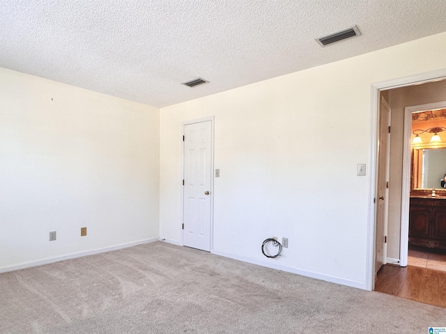 carpeted spare room with a textured ceiling