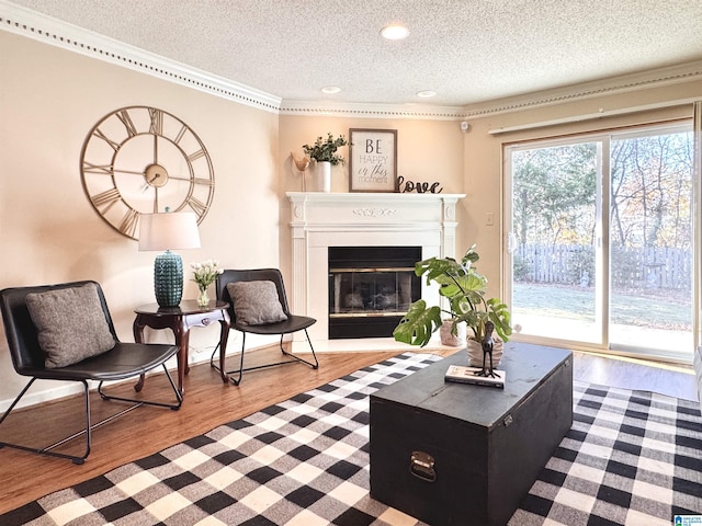 living room with ornamental molding, a textured ceiling, and light hardwood / wood-style flooring