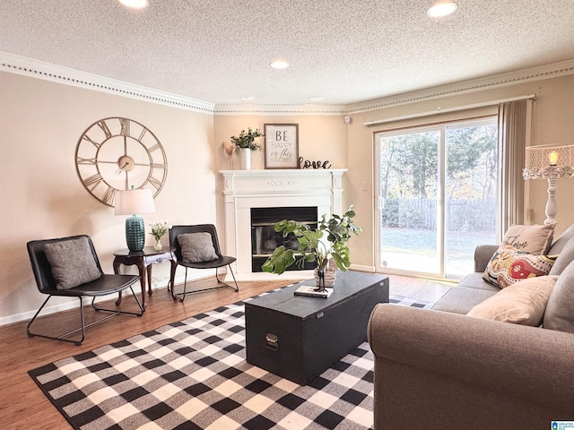 living room featuring hardwood / wood-style flooring, ornamental molding, and a textured ceiling