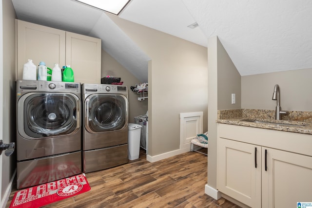 clothes washing area with washer and clothes dryer, sink, and dark hardwood / wood-style floors