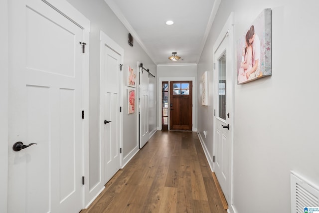 doorway featuring hardwood / wood-style flooring, a barn door, and ornamental molding