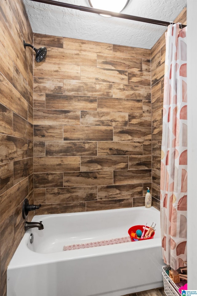 bathroom with shower / bath combination with curtain, wood walls, and a textured ceiling