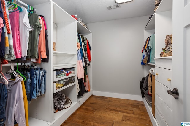 walk in closet with dark wood-type flooring