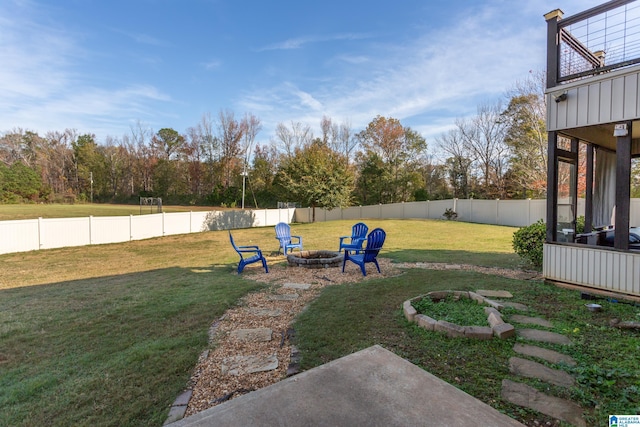 view of yard featuring a balcony and an outdoor fire pit