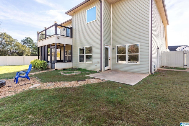 back of house featuring a yard, a patio area, a sunroom, and a balcony