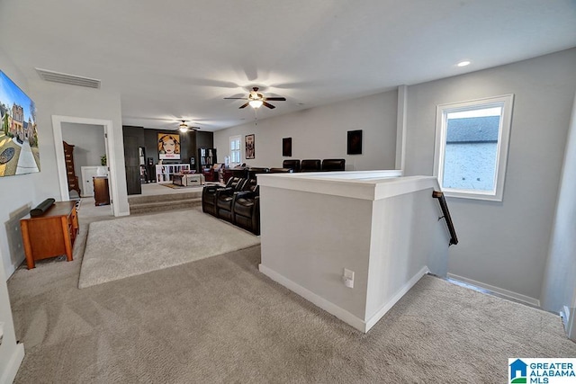 interior space with ceiling fan and light colored carpet