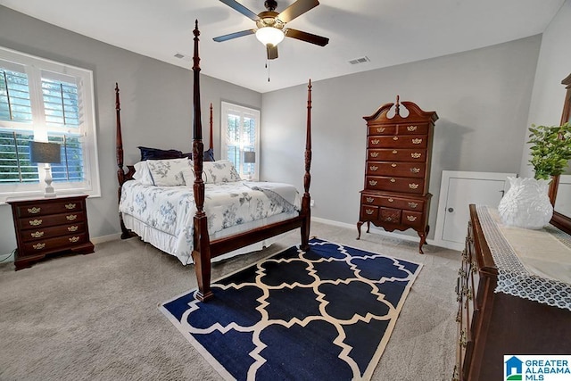 carpeted bedroom with ceiling fan and multiple windows