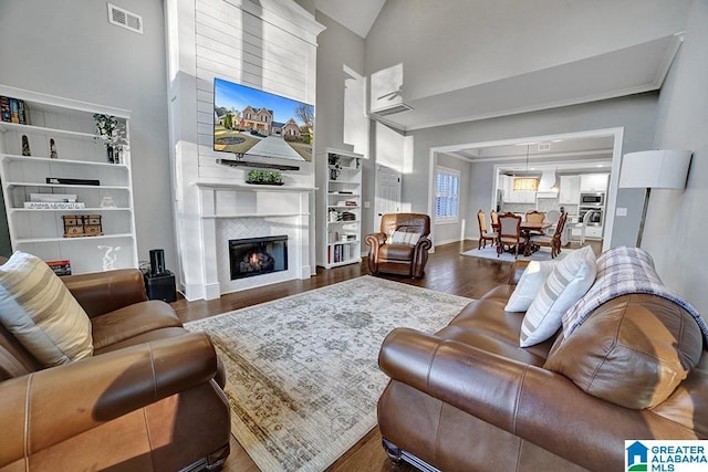 living room with built in shelves, a fireplace, high vaulted ceiling, and dark wood-type flooring