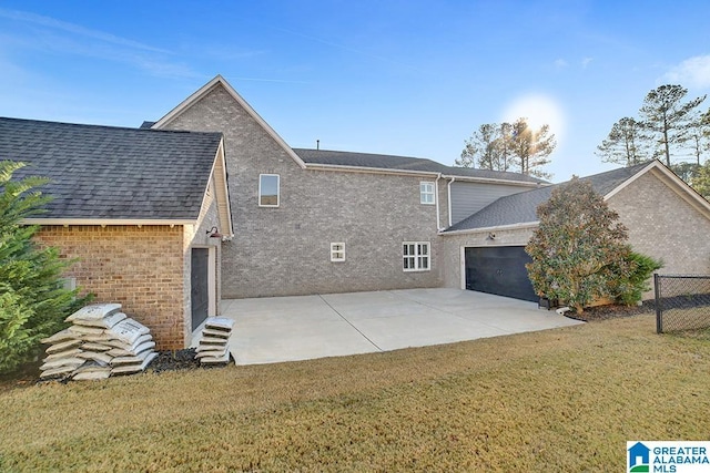 back of house with a yard and a garage