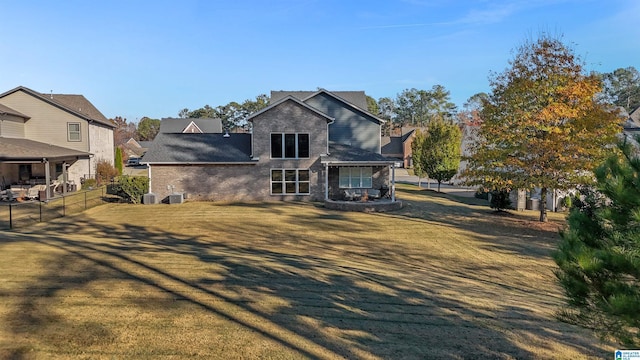 view of front of home featuring central AC and a front lawn