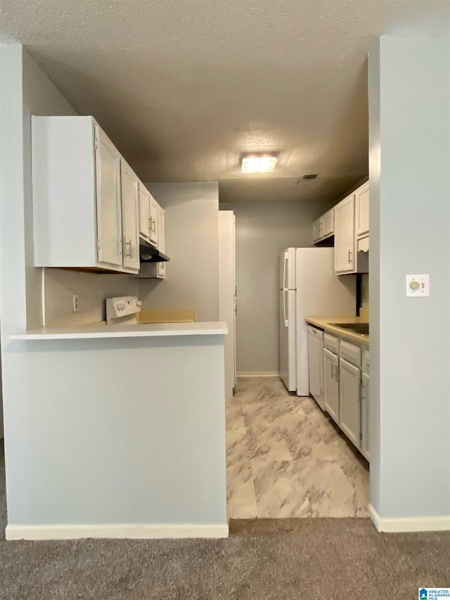 kitchen featuring kitchen peninsula, a textured ceiling, white dishwasher, and white cabinetry