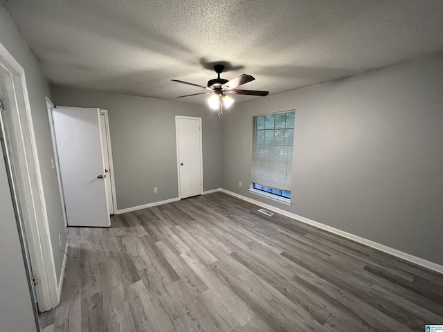 unfurnished bedroom featuring ceiling fan, light hardwood / wood-style flooring, and a textured ceiling