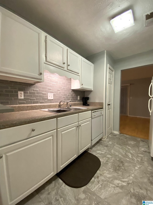 kitchen featuring decorative backsplash, dishwasher, white cabinets, and sink