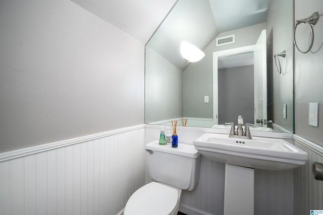 bathroom featuring sink, lofted ceiling, and toilet