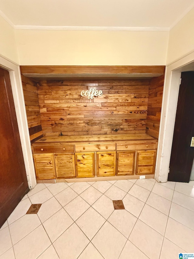 interior space featuring light tile patterned floors, crown molding, and wooden walls