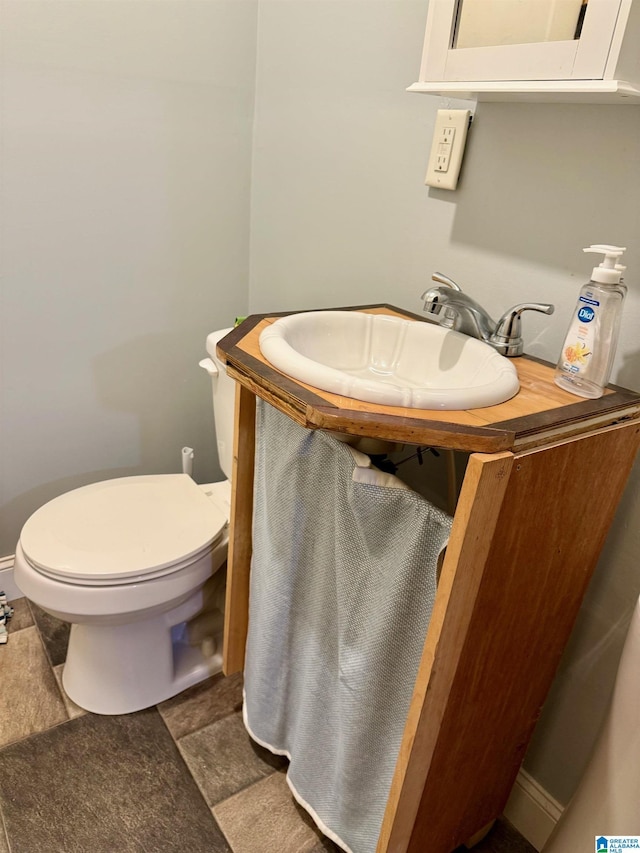 bathroom featuring tile patterned flooring, toilet, and sink