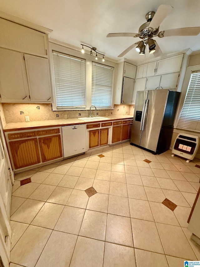 kitchen featuring white dishwasher, ceiling fan, light tile patterned floors, stainless steel fridge with ice dispenser, and heating unit