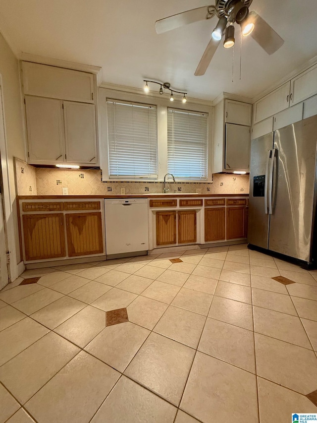 kitchen featuring white dishwasher, ceiling fan, stainless steel fridge, light tile patterned floors, and tasteful backsplash