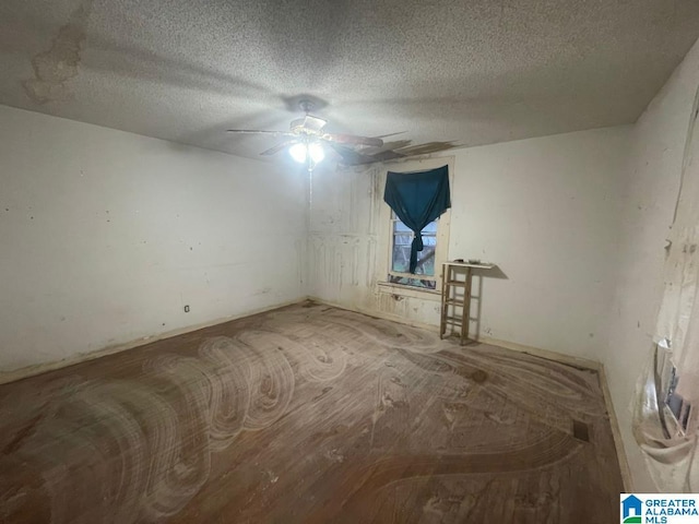 unfurnished room with ceiling fan and a textured ceiling