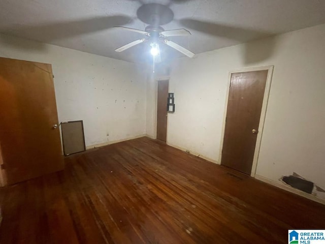 empty room featuring ceiling fan and dark wood-type flooring