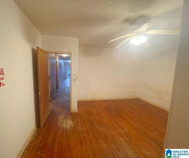 spare room with hardwood / wood-style floors, a textured ceiling, and ceiling fan