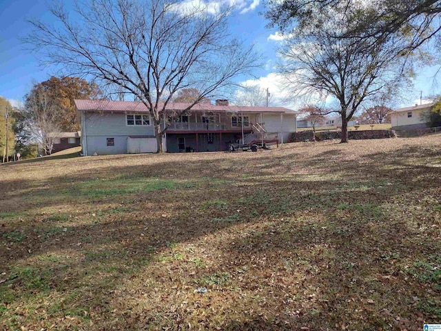 rear view of property with a deck and a lawn