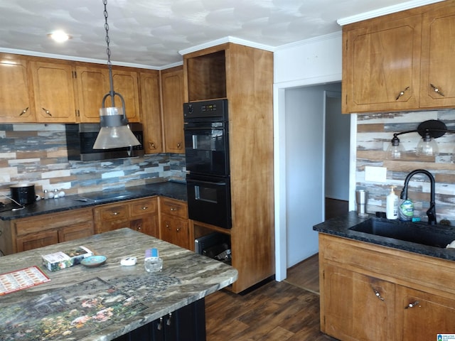 kitchen featuring dark stone counters, black appliances, sink, dark hardwood / wood-style floors, and decorative backsplash