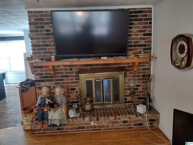 room details with crown molding, hardwood / wood-style floors, and a brick fireplace