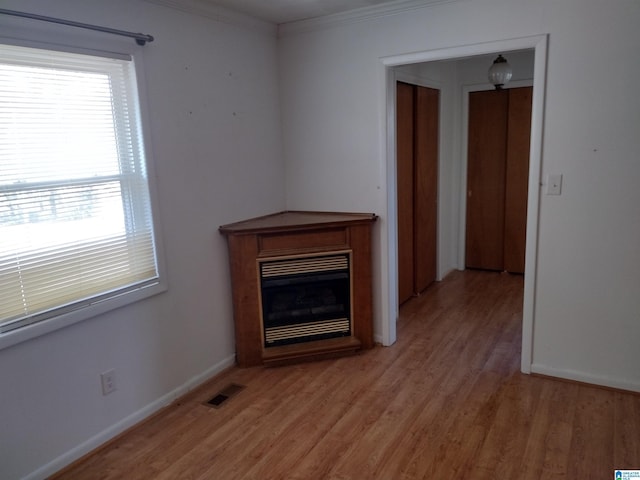 unfurnished living room with wood-type flooring and ornamental molding