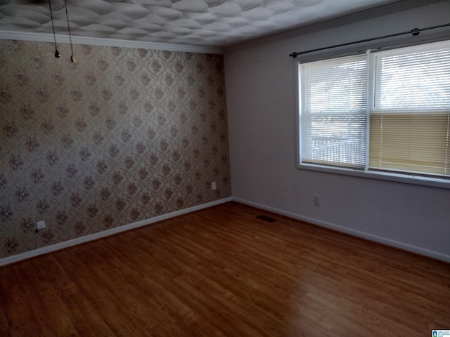 spare room with hardwood / wood-style flooring and ornamental molding