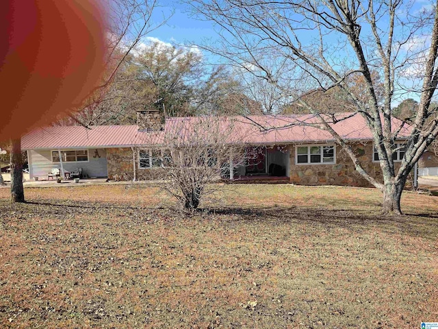 420 Dennis St, Weaver, AL 36277 - view of front facade featuring stone siding, a front lawn, a chimney, and metal roof