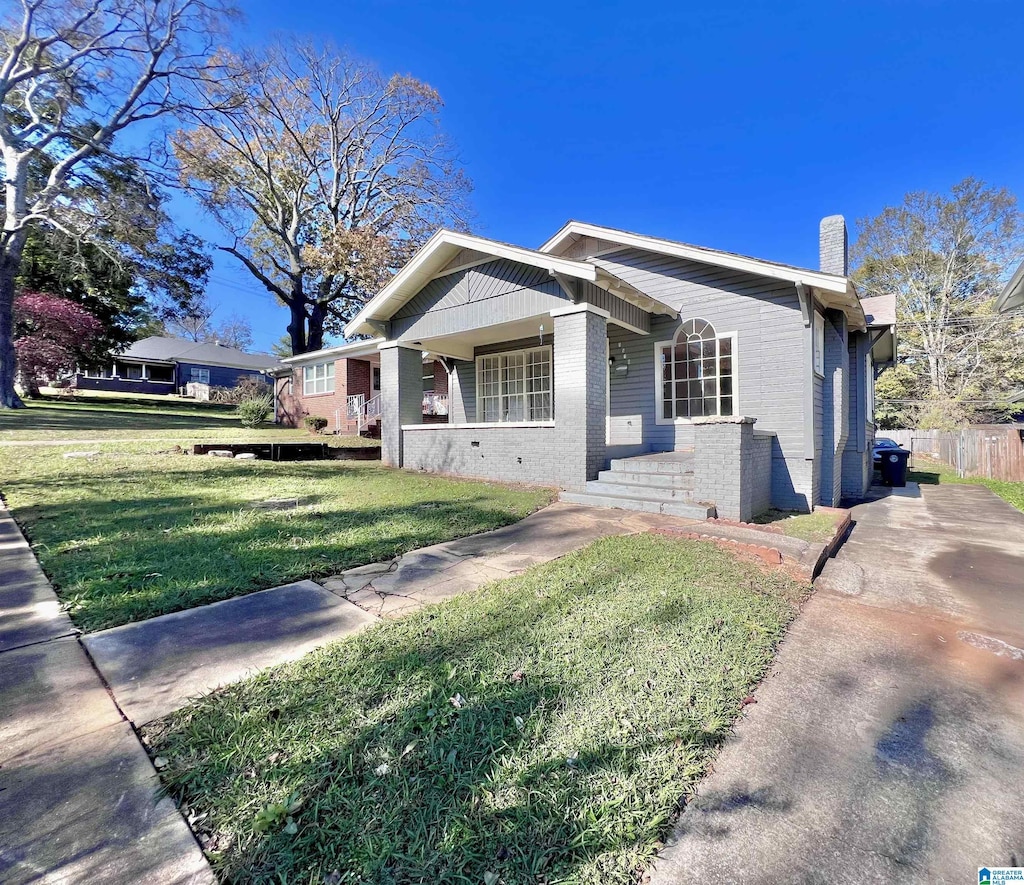 view of front of house with covered porch and a front yard