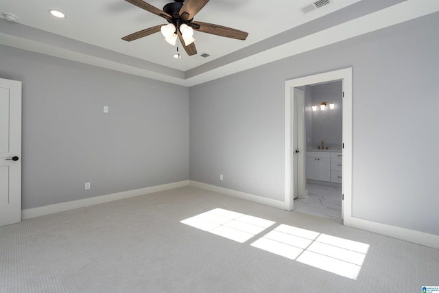 unfurnished bedroom with light carpet, connected bathroom, and ceiling fan