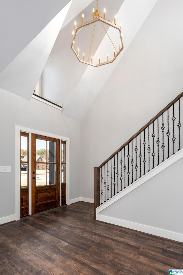 entryway featuring high vaulted ceiling, dark wood-type flooring, and a notable chandelier