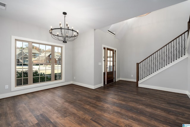 entryway with dark wood-type flooring and an inviting chandelier