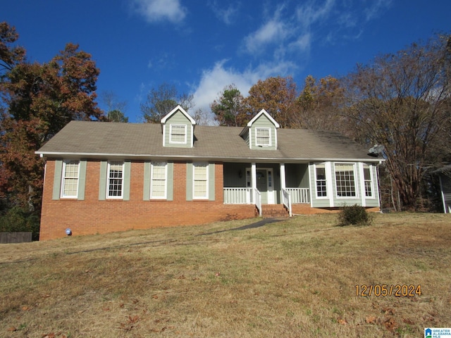 cape cod home featuring covered porch and a front yard