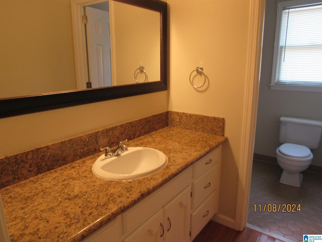 bathroom with tile patterned flooring, vanity, and toilet