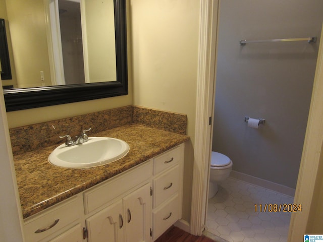 bathroom featuring tile patterned flooring, vanity, and toilet