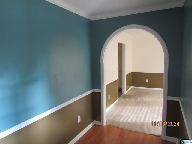 empty room featuring hardwood / wood-style floors and crown molding