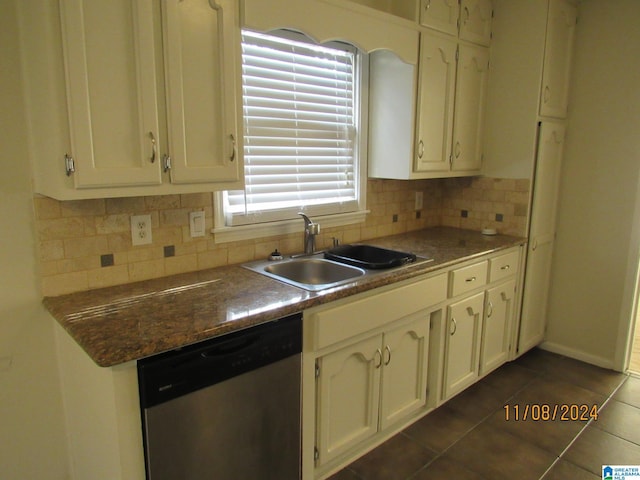 kitchen with dishwasher, dark tile patterned floors, sink, and tasteful backsplash