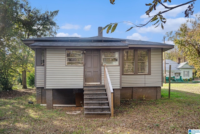 rear view of house featuring a lawn