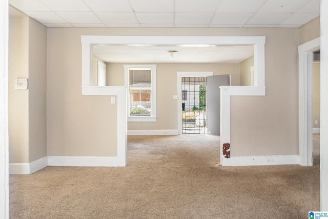 carpeted empty room with a paneled ceiling