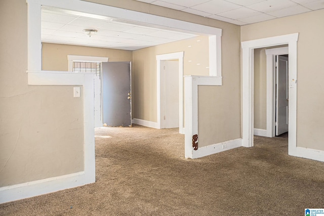 carpeted spare room featuring a paneled ceiling